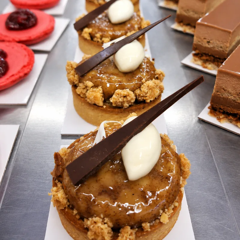 Tarts, red macarons and chocolate cakes in the Envie French Bakery display cabinet