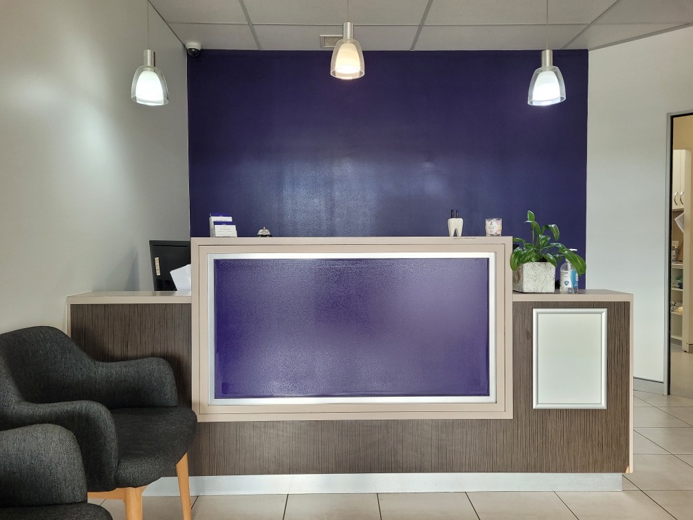 Sunny Dental Buderim — finished reception with deep purple feature wall