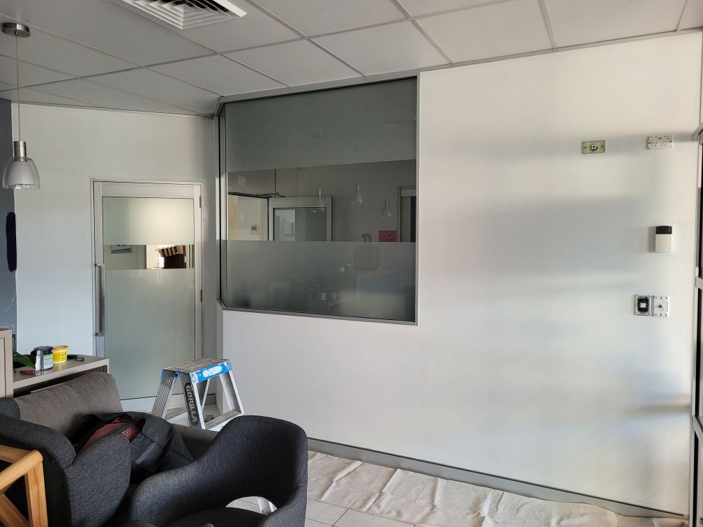 Reception walls being prepped with white primer during the Sunny Dental renovation